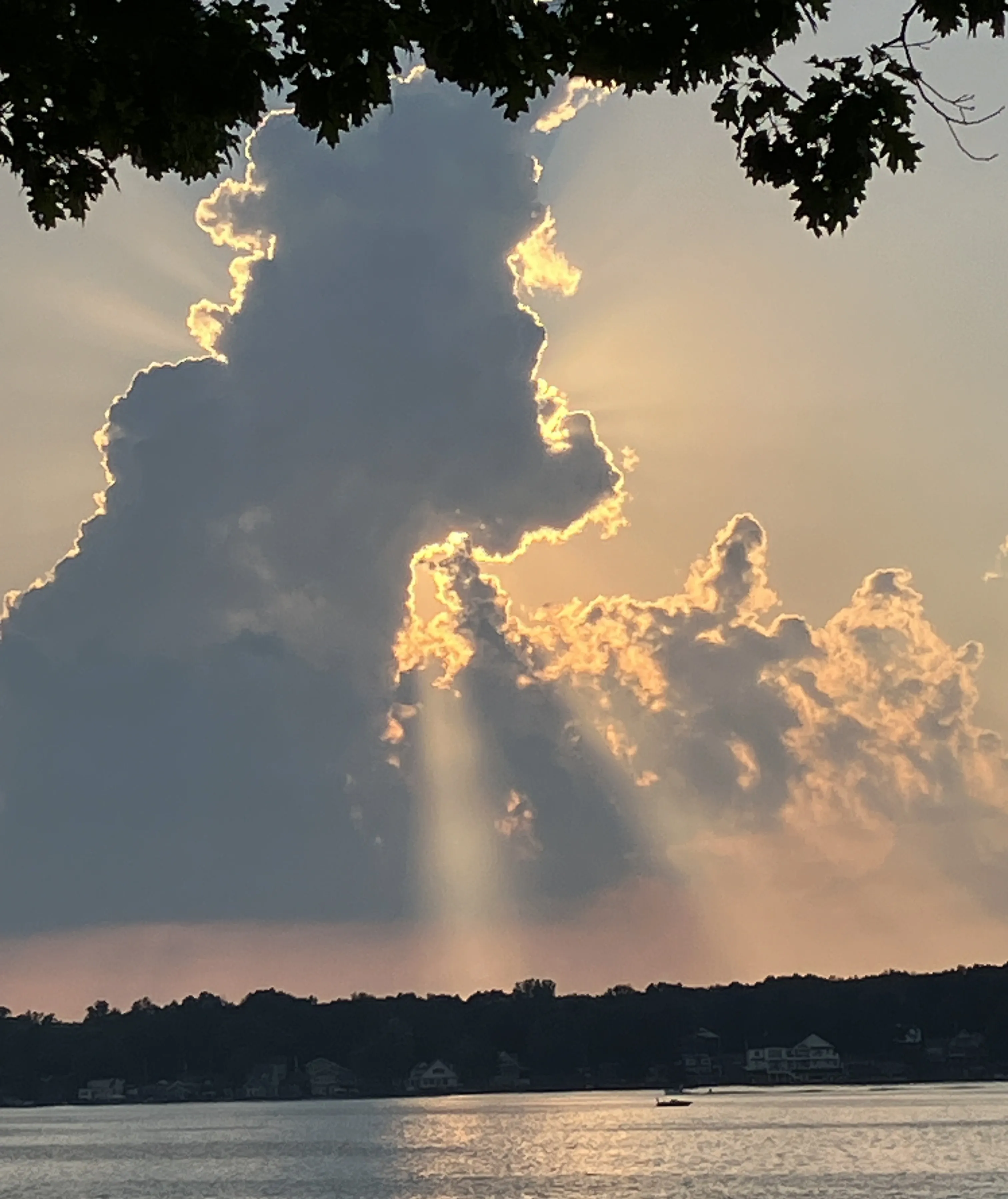 Rays of light breaking through clouds over the lake.